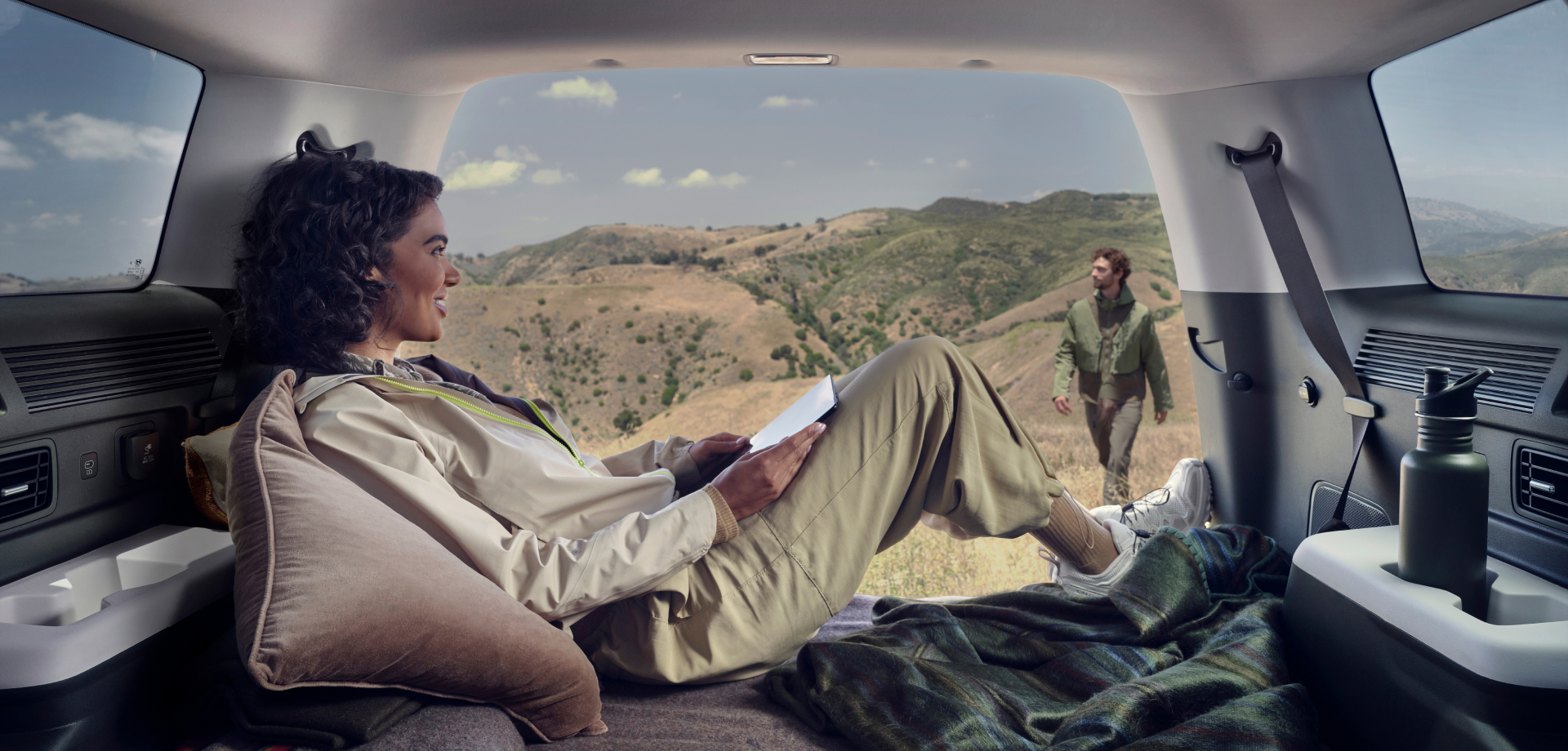 Woman relaxing in Hyundai Santa Fe's cargo area.