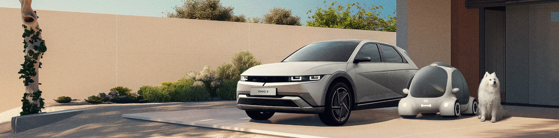 An IONIQ 5 is parked next to a Dogability autonomous car model and its canine owner.