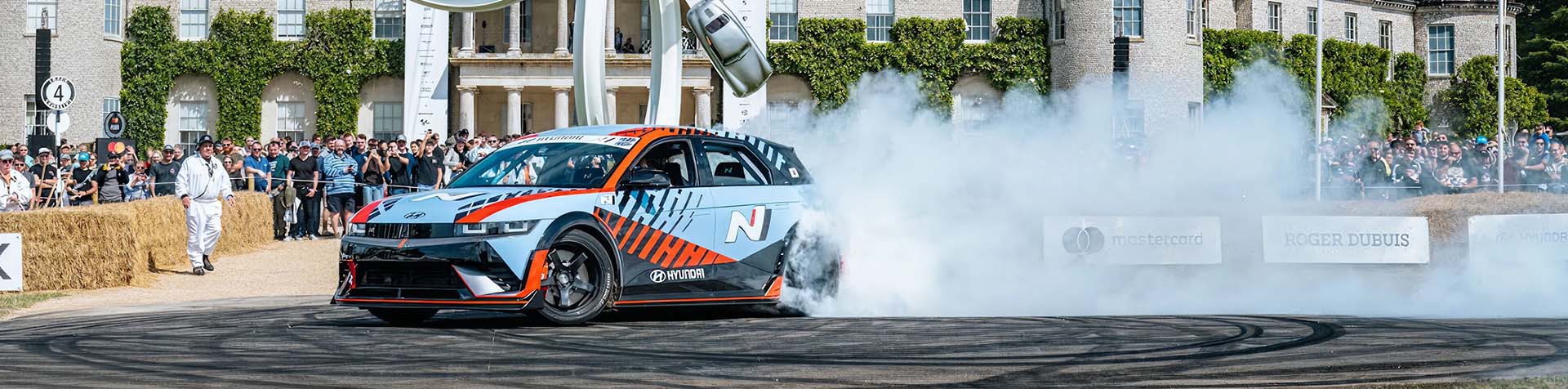 A Hyundai IONIQ 5 N performs donuts by spinning in circles during a demonstration