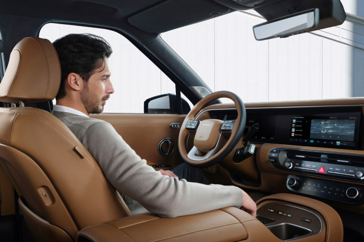 A man relaxing comfortably in the all-new PALISADE during Stay Mode.