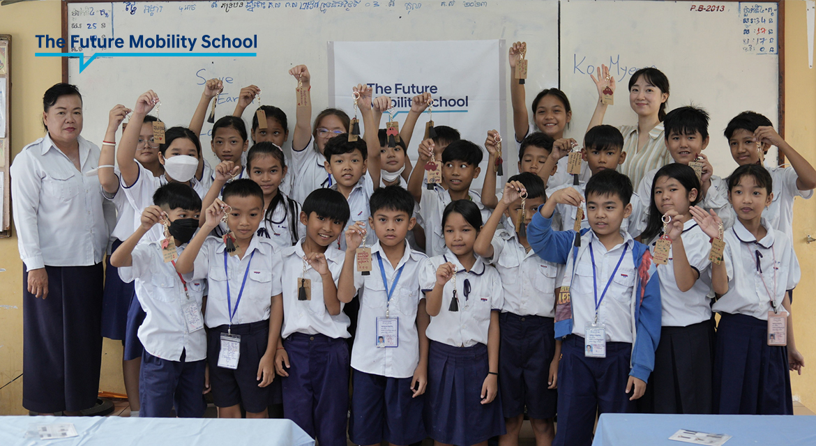A group of students in the Future Mobility School class are showing the upcycled keychains they made in the class