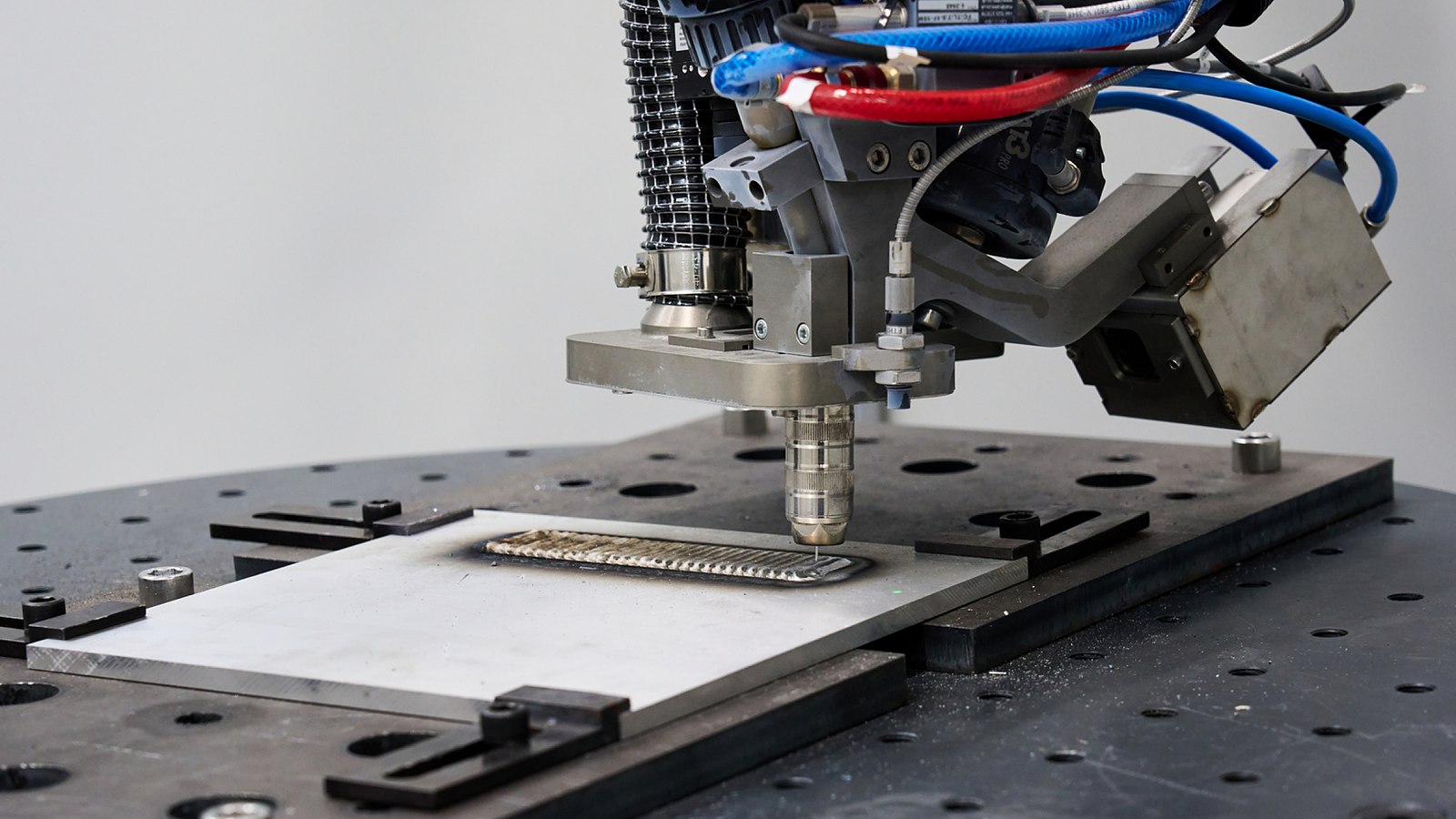 A DED-WAAM (Directed Energy Deposition-Wire Arc Additive Manufacturing) system fabricates a metal component by depositing material layer by layer.