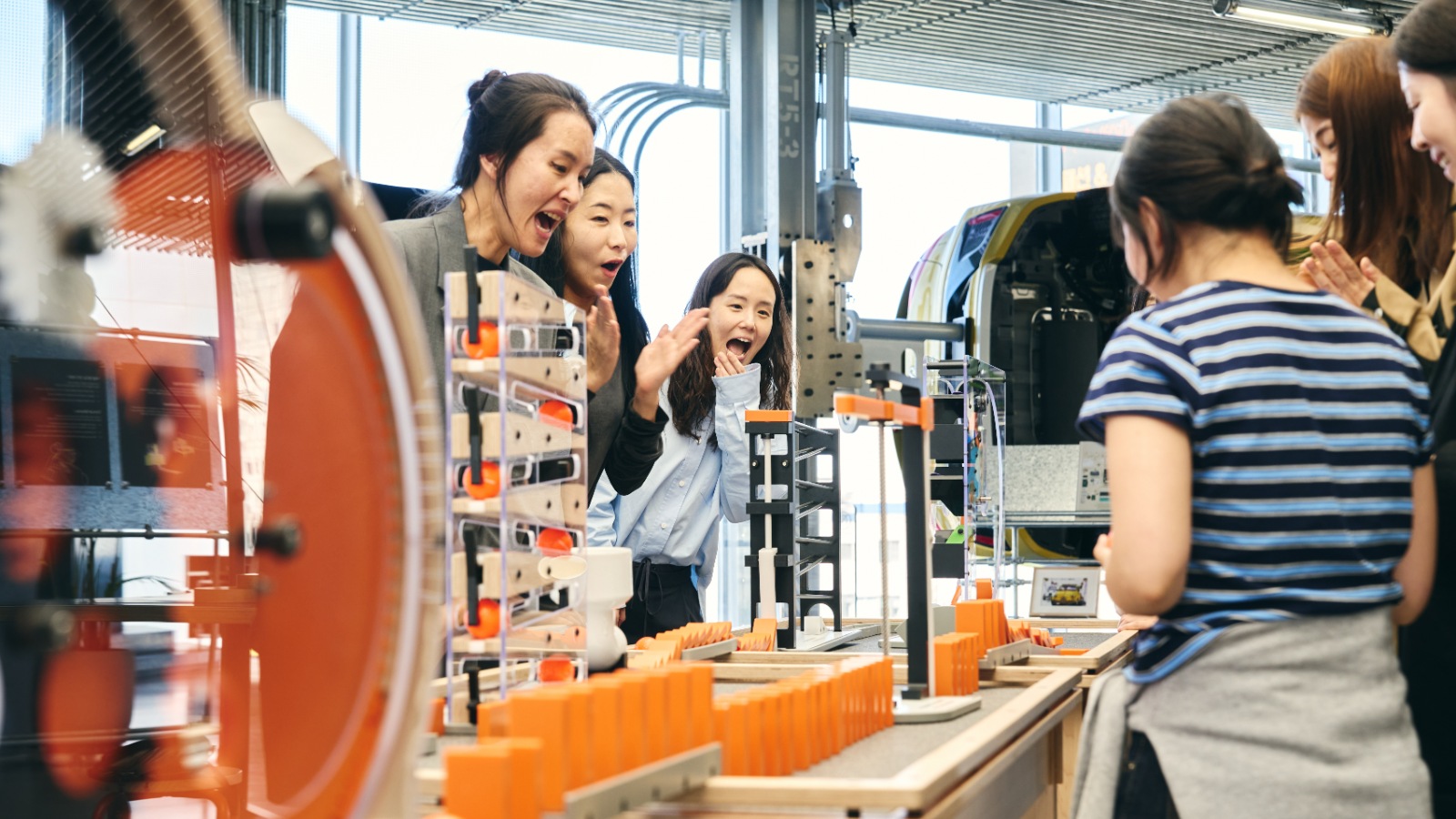 Visitors interacting with Chain Reaction, a featured exhibit in 'Have Fun with Science,' a pop-up exhibition for the GBC experiential science museum.